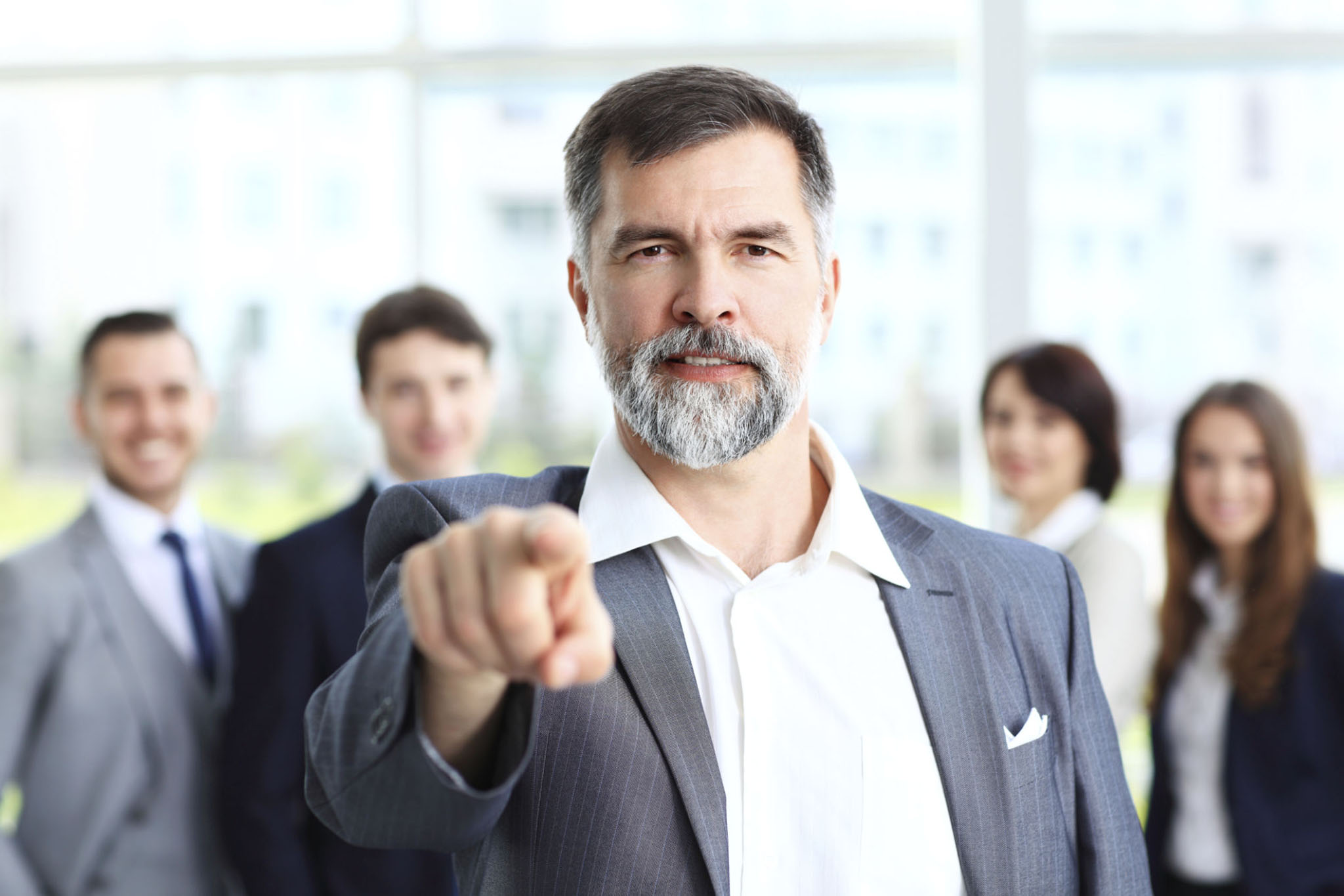 Leader decisively pointing forward with team behind