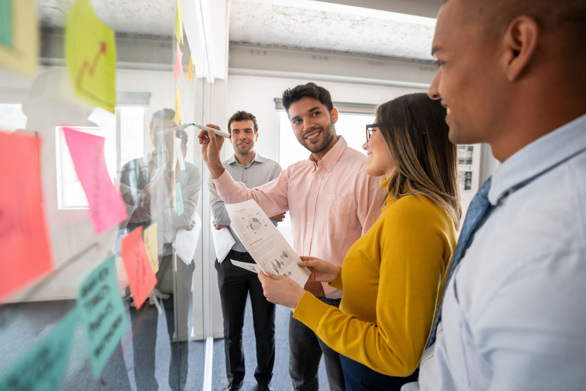 Diverse team collaborating intensely around a whiteboard